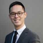 Headshot of Kenneth Lam, MD, MAS from the shoulders up, smiling and wearing a suit.